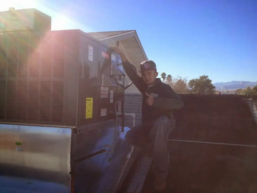 HVAC technician performing Air Duct Cleaning on a rooftop unit in Chicago